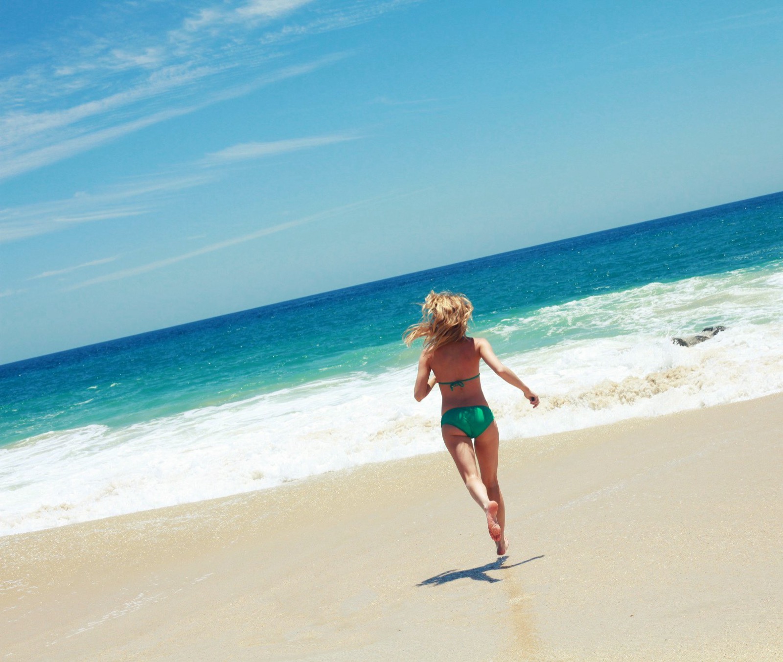 Katy running down the beach toward the waves