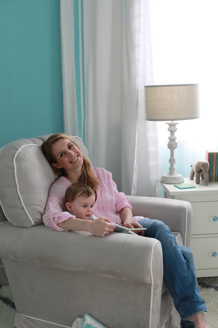 Katy reading with her first baby in the nursery